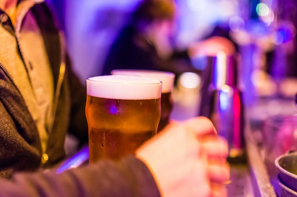 person at bar with a beer